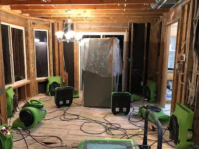 Green air movers drying a gutted room to the studs in Gresham, OR